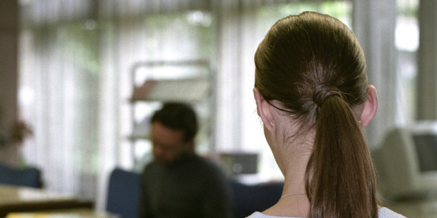 Brownhaired Woman waiting behind an Information-Desk - Employment Office