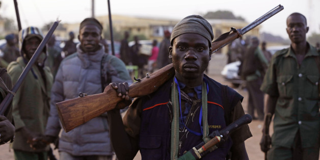 FILE-In this file photo taken on Wednesday, Nov. 25, 2014 file photo, vigilantes and local hunters armed with locally made guns gather before they go on patrol in Yola, Nigeria. First come the whispers, then accusations loud enough to raise alarms throughout villages ravaged by extremist violence. Next, people accused of being Boko Haram are rounded up, sometimes by the military, sometimes by a civilian self-defense force. Many are never seen again. (AP Photo/Sunday Alamba, File)