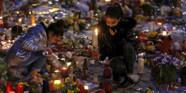 Girls light candles as people pay tribute to the victims of Tuesday's bomb attacks, at the Place de la Bourse in Brussels, Belgium, March 26, 2016. REUTERS/Christian Hartmann