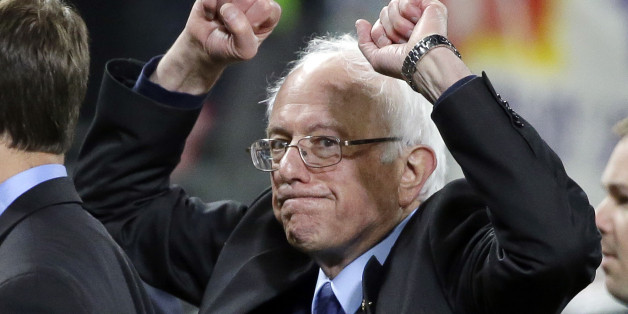 Democratic presidential candidate Sen. Bernie Sanders, I-Vt., pumps his fists as he leaves the field after speaking at a rally Friday, March 25, 2016, in Seattle. (AP Photo/Elaine Thompson)