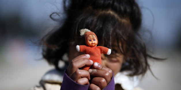 A migrant girl shows her doll in the makeshift refugee camp at the northern Greek border point of Idomeni, Greece, Saturday, March 26, 2016. Greece's border with Macedonia has been shut to refugees since earlier this month after a string of countries shut down the route which migrants used to go from Greece to central and northern Europe. Those stranded in the camp and surrounding fields have been living in dire conditions in small tents pitched in muddy fields. (AP Photo/Darko Vojinovic)