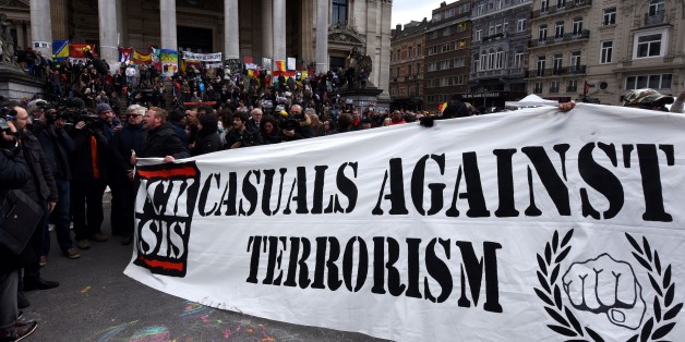 A group of people march behind a banner of the 'FCK-Casuals' hooligan movement, as they arrive in the square outside the stock exchange in Brussels on March 27, 2016 as tensions mounted after the square was invaded by some 200 far-right football hooligans.
Police fired water a cannon at far-right football hooligans who invaded a square in the Belgian capital that has become a memorial to the victims of the Brussels attacks, an AFP journalist said. Police took action after about 200 black-clad hooligans shouting nationalist and anti-immigrant slogans moved in on the Place de la Bourse where people were gathering in a show of solidarity with the victims.
/ AFP / PATRIK STOLLARZ (Photo credit should read PATRIK STOLLARZ/AFP/Getty Images)