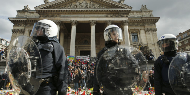 Police in riot gear protect one of the memorials to the victims of the recent Brussels attacks, a right wing demonstrators protest near the Place de la Bourse in Brussels, Sunday, March, 27, 2016. In a sign of the tensions in the Belgian capital and the way security services are stretched across the country, Belgium's interior minister appealed to residents not to march Sunday in Brussels in solidarity with the victims."We understand fully the emotions," Interior Minister Jan Jambon told repor