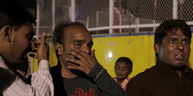 Men mourn the death of their relatives after a blast outside a public park in Lahore, Pakistan, March 27, 2016. REUTERS/Mohsin Raza