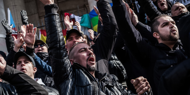 Right wing demonstrators protest at a memorial site at the Place de la Bourse in Brussels, Sunday, March 27, 2016. In a sign of the tensions in the Belgian capital and the way security services are stretched across the country, Belgium's interior minister appealed to residents not to march Sunday in Brussels in solidarity with the victims. (AP Photo/Valentin Bianchi)