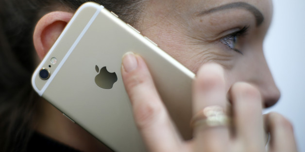 A woman uses her mobile phone, an iPhone 6 by Apple in Munich downtown, Germany, January 27, 2016. REUTERS/Michaela Rehle