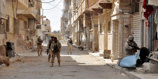 Forces loyal to Syria's President Bashar al-Assad walk with their weapons in Palmyra city after they recaptured it, in Homs Governorate in this handout picture provided by SANA on March 27, 2016. REUTERS/SANA/Handout via Reuters ATTENTION EDITORS - THIS PICTURE WAS PROVIDED BY A THIRD PARTY. REUTERS IS UNABLE TO INDEPENDENTLY VERIFY THE AUTHENTICITY, CONTENT, LOCATION OR DATE OF THIS IMAGE. FOR EDITORIAL USE ONLY. NOT FOR SALE FOR MARKETING OR ADVERTISING CAMPAIGNS. THIS PICTURE IS DISTRIBUTED E