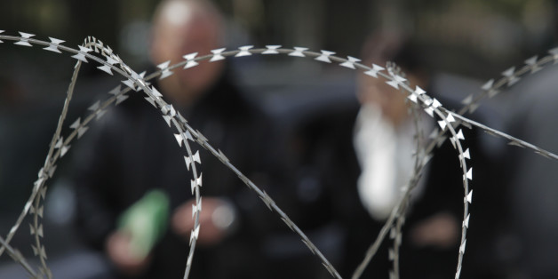 A couple walks past behind barbed wire set up by the military to protect the French Embassy on Avenue Bourgiba in downtown Tunis, Tunisia, Monday , March 14, 2011. At the height of the Tunisian uprising, leader Zine El Abidine Ben Ali tried hard to silence the young bloggers driving the protests against him: his security agents arrested, even tortured, some of them and repeatedly shut down their sites. Social media were key to the Tunisian revolt and the anti-government protests it inspired across the Arab world. (AP Photo/Lefteris Pitarakis)