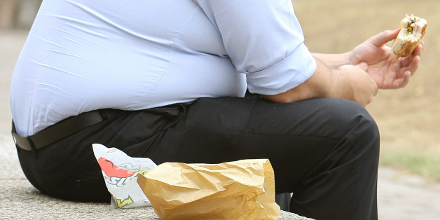 File photo dated 28/07/10 of an overweight man eating, as it was proposed that GPs should be paid to measure their patients' BMI.