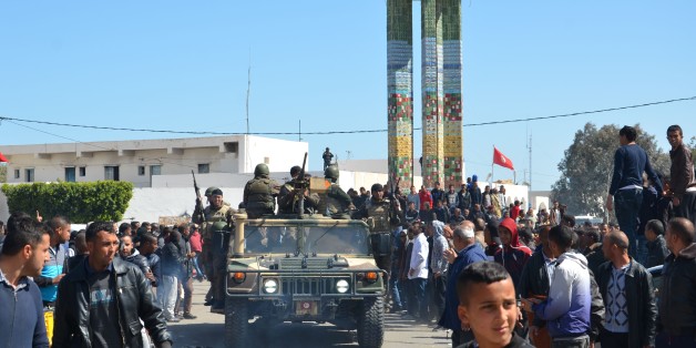 Tunisians wave to a military convoy during a visit of the prime minister in Ben Guerdane on March 13, 2016, a week after jihadists launched a wave of attacks on army and police posts in the border town. / AFP / FATHI NASRI (Photo credit should read FATHI NASRI/AFP/Getty Images)