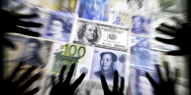 Hands are silhouetted against a backdrop projected with the picture of various currencies of money in this illustration taken April 4, 2016. REUTERS/Kacper Pempel/Illustration