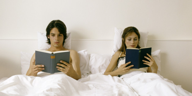 couple lying in bed, reading books