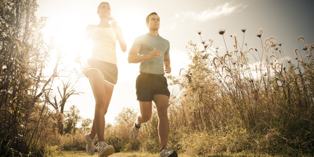 Caucasian couple running together on path