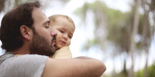 Dad kissing uncomfortable boy