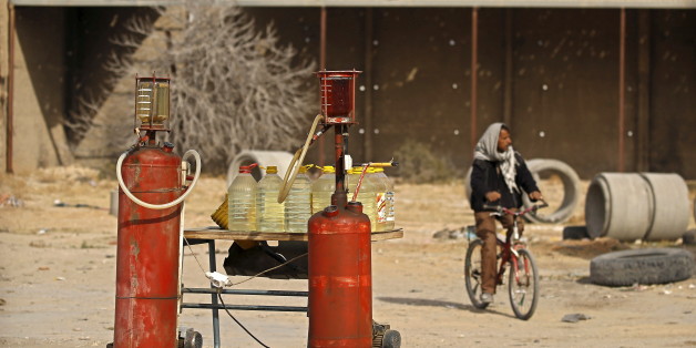A man rides a bicycle as he passes tanks of gasoline in Kasserine, Tunisia January 30, 2016. A litre of fuel is priced at 1.5 Tunisian dinars ($0.74). A dramatic drop in oil prices, driven down by a glut in supply, is translating into a mixed bag for motorists. All countries have access to the same oil prices on international markets, but retail prices vary wildly, largely because of taxes and subsidies. REUTERS/Zohra Bensemra SEARCH "THE WIDER IMAGE" FOR ALL STORIES TPX IMAGES OF THE DAY