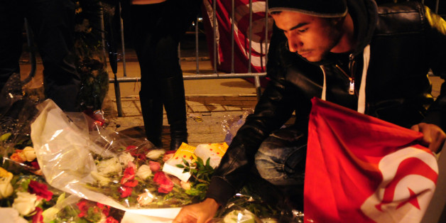 Tunisian citizens leave flowers and light up candles at Mohamed V avenue in memory of the 12 martyrs. The Islamic State group claimed responsibility for Tuesday's attack on a bus in central Tunis, which left 12 dead plus the attacker. (AP Photo/Riadh Dridi)