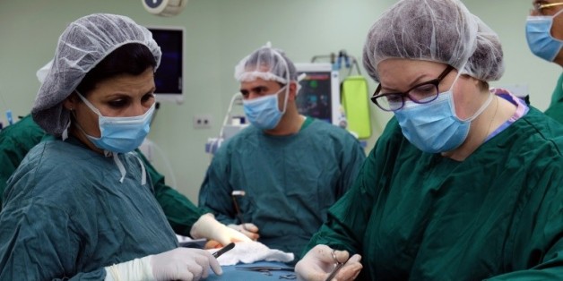 Photo fournie par l'organisation britannique Medical Aid for the Palestinians, prise le 30 mars 2016, montrant Philippa Whitford (d), en train d'opérer pour un cancer du sein une Palestinienne à Jérusalem