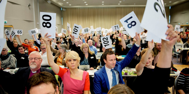 Norwegian Church Council leader Kristin Gunleiksrud Raaum (in red) and Chairman of the Oslo diocesan council Gard Sandaker-Nielsen (R) vote on a proposal to allow same-sex marriage within the Norwegian Church, in Oslo, Norway April 11, 2016. REUTERS/Ole Martin Wold/NTB Scanpix ATTENTION EDITORS - THIS IMAGE WAS PROVIDED BY A THIRD PARTY. FOR EDITORIAL USE ONLY. NOT FOR SALE FOR MARKETING OR ADVERTISING CAMPAIGNS. THIS PICTURE IS DISTRIBUTED EXACTLY AS RECEIVED BY REUTERS, AS A SERVICE TO CLIE
