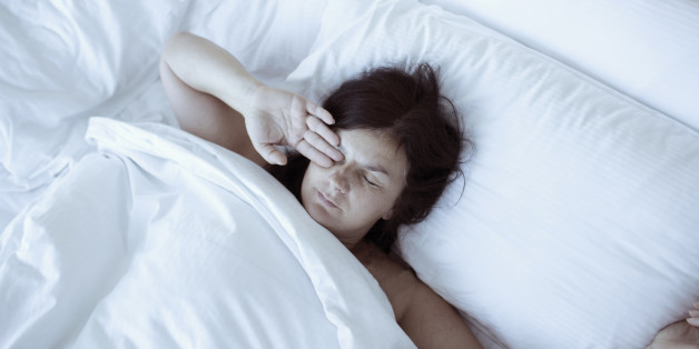 Sleepy woman waking up in bed.