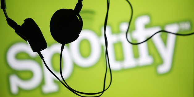 Headsets hang in front of a screen displaying a Spotify logo on it, in Zenica February 20, 2014. Online music streaming service Spotify is recruiting a U.S. financial reporting specialist, adding to speculation that the Swedish start-up is preparing for a share listing, which one banker said could value the firm at as much as $8 billion (4 billion pounds). REUTERS/Dado Ruvic (BOSNIA AND HERZEGOVINA - Tags: SCIENCE TECHNOLOGY BUSINESS SOCIETY)