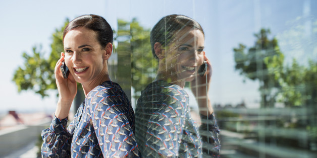 Smiling businesswoman talking on cell phone outdoors