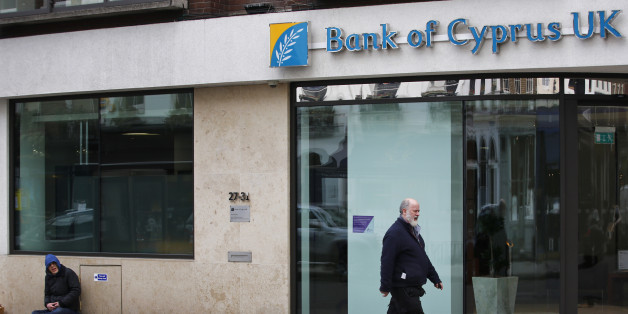 A man walks past a beggar outside a Bank Of Cyprus UK branch in central London, Thursday, March 28, 2013. Banks in Cyprus reopened to customers for the first time in nearly two weeks Thursday, albeit with strict restrictions on transactions, after being closed to prevent people withdrawing all their savings during the countryâs acute financial crisis. Bank of Cyprus UK Limited, a separately capitalized UK incorporated bank, is subject to UK financial regulation, and eligible depositors are protected by the UKâs Financial Services Compensation Scheme (AP Photo/Lefteris Pitarakis)