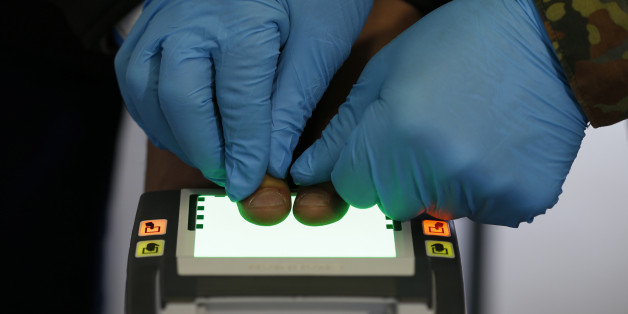 An official scans migrant's fingerprints during a registration in the first registration camp of Erding near Munich, Germany, January 27, 2016. REUTERS/Michaela Rehle TPX IMAGES OF THE DAY