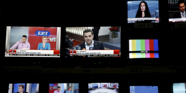Greek Prime Minister Alexis Tsipras is seen on a monitor screen (C) at the control room during the first broadcast of state television ERT after its reopening in Athens June 11, 2015. Employees at Greece's state television ERT hugged each other and cried on Thursday as the channel aired its first broadcast in two years, after it was shut down under one of the previous government's most drastic austerity measures. Leftist Prime Minister Alexis Tsipras, who is racing to reach a cash-for-reforms deal with the European Union and IMF, had called ERT's closure "a great wound" of his country's bailout. He made its reopening one of his priorities as part of efforts to roll back cuts demanded by the lenders. REUTERS/Alkis Konstantinidis