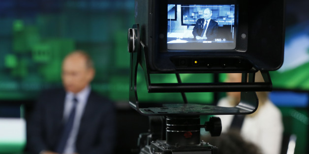 FILE - In this Tuesday, June 11, 2013 file photo, Russian President Vladimir Putin is shown on the screen of a camera viewfinder at the new headquarters of "Russia Today" television channel in Moscow, Russia. Major brands in the export division of Russian media include RT, the RIA Novosti news agency and its English-language arm Sputnik, and the Voice of Russia radio station. Despite the pounding Russiaâs economy is taking from the slump in the price of crude oil and the Westâs Ukraine-related sanctions, the annual government budget allocation for RT alone has been hiked by 30 percent since 2014, to the ruble equivalent of $289 million. (Yuri Kochetkov/Pool Photo via AP, File)