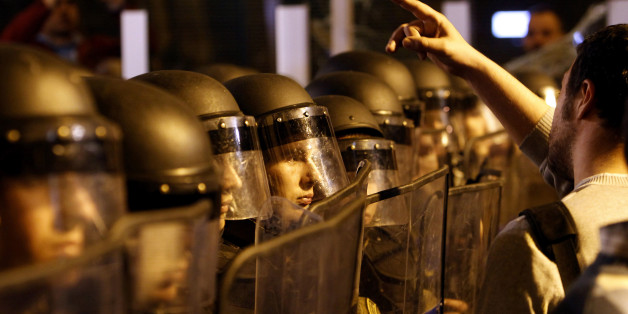 Protestors confront the police in downtown Skopje, Macedonia, Tuesday, April 12, 2016. Several hundred people protested late Tuesday outside the offices of the ruling conservative VMRO-DPMNE party and in front of President Ivanov office in downtown Skopje, throwing eggs and demanding his resignation. Macedonian President Gjorge Ivanov has announced earlier Tuesday he is granting a presidential pardon terminating all criminal proceedings against politicians from both the ruling parties and the opposition. (AP Photo/Boris Grdanoski)