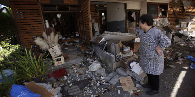 A local resident cleans up her house in Mashiki, Kumamoto prefecture, southern Japan, Friday, April 15, 2016. Aftershocks rattled communities in southern Japan as businesses and residents got a fuller look Friday at the widespread damage from an unusually strong overnight earthquake. (AP Photo/Koji Ueda)