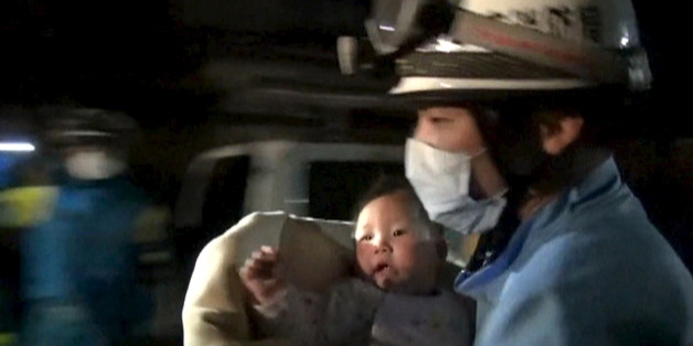 An eight-month-old baby is carried away by a rescue worker after being rescued from her collapsed home caused by an earthquake in Mashiki town, Kumamoto prefecture, southern Japan, April 15, 2016 early morning, in this handout still image from a video provided by Kumamoto Prefectural Police. REUTERS/Kumamoto Prefectural Police/Handout via Reuters ATTENTION EDITORS - FOR EDITORIAL USE ONLY. NOT FOR SALE FOR MARKETING OR ADVERTISING CAMPAIGNS. NO RESALES. NO ARCHIVE. THIS IMAGE HAS BEEN SUPPLIED