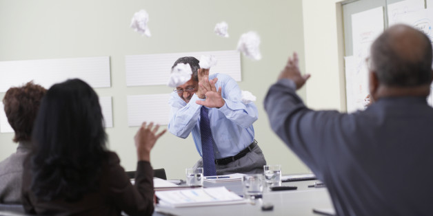 Businesspeople throwing paper balls