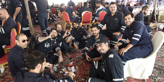 Kuwaiti oil sector employees sit in a shaded area on the first day of an official strike called by the Oil and Petrochemical Industries Workers Union over public sector pay reforms, in Ahmadi, Kuwait April 17, 2016. REUTERS/Stephanie McGehee