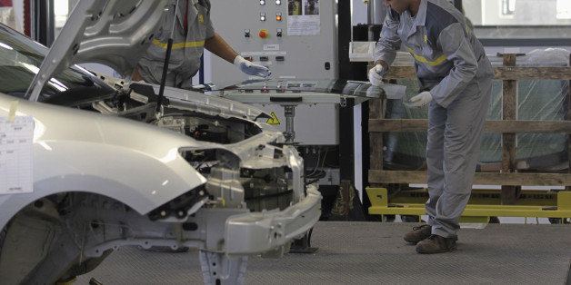 Employees work in the new Renault factory in Oran, west of Algiers November 10, 2014. French carmaker Renault said on Monday it was targeting annual production capacity of 25,000 vehicles at a new plant in Oran, Algeria, and that it was considering increasing this to 75,000 vehicles. Renault, which said it was Algeria's biggest carmaker with a market share of more than 25 percent, owns 49 percent of the plant and has made an initial investment of 50 million euros ($62 million), it said in a stat