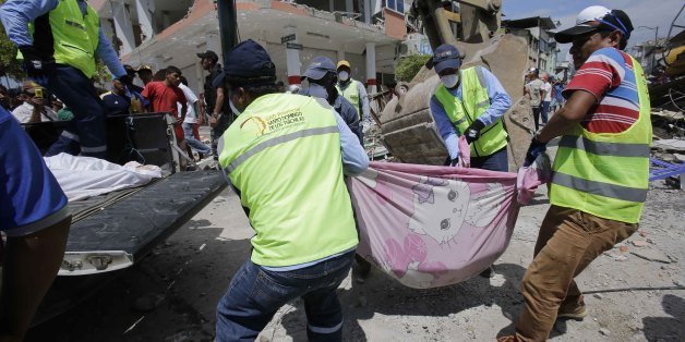 Volunteers carry a body pulled from the rubble in Pedernales, Ecuador, Sunday, April 17, 2016. Rescuers pulled survivors from rubble Sunday after the strongest earthquake to hit Ecuador in decades flattened buildings and buckled highways along its Pacific coast. (AP Photo/Dolores Ochoa)