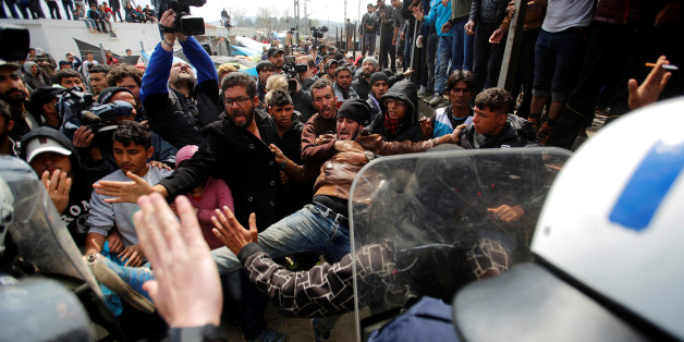 Die griechische Polizei steht vor einer großen Gruppe verzweifelter Flüchtlinge Mitte April