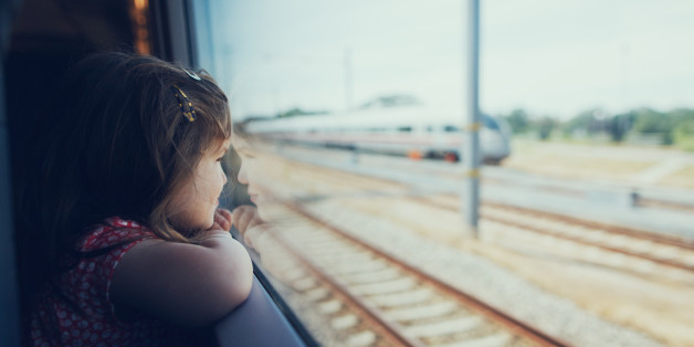 Young girl looking through the window in the train on the move