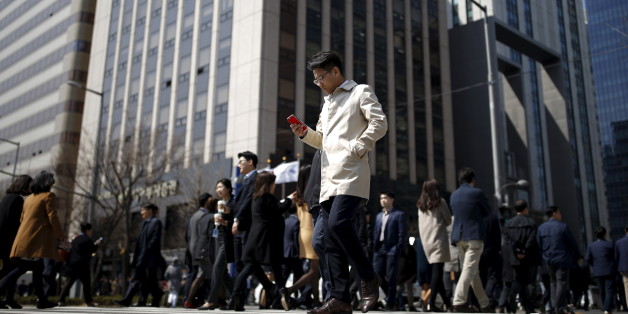 A man using his mobile phone walks on a zebra crossing at a business district in Seoul, South Korea, March 23, 2016. Picture taken on March 23, 2016. REUTERS/Kim Hong-Ji