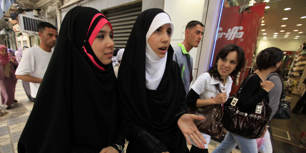 A veiled woman smiles as another talks to journalists in Algiers May 10, 2010. A French proposal to ban full face veils has stoked debate in Europe and also provoked strong reactions across the Mediterranean in North Africa, where many of France's Muslims trace their origins. People in North Africa are split between those who see the proposed ban -- a version of which has already been approved by Belgium's lower house of parliament -- as an attack on Islam, and those who applaud Europe for defending secular values. Picture taken May 10, 2010. To match feature EUROPE-VEIL/NORTHAFRICA REUTERS/Zohra Bensemra (ALGERIA - Tags: POLITICS RELIGION SOCIETY)