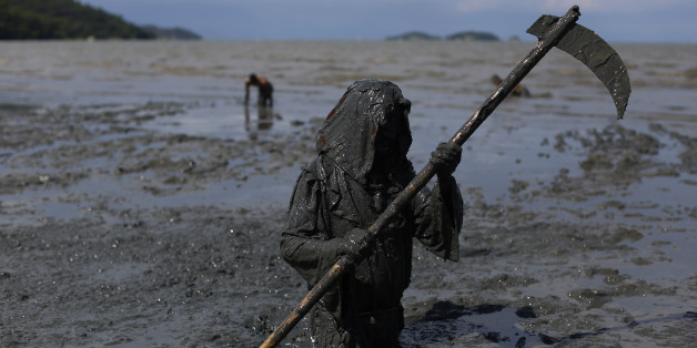 A mud covered reveler wearing a grim reaper costume enjoys the traditional "Bloco da Lama" or "Mud Block" carnival party, in Paraty, Brazil, Saturday, Feb. 14, 2015. Revelers in the seaside colonial town threw themselves into deposits of black, mineral-rich slime, emerging covered head-to-toe in the sludge. Bikinis and trunks disappeared beneath the mud, which highlights both gym-pumped pectorals and beer-fed guts. (AP Photo/Leo Correa)