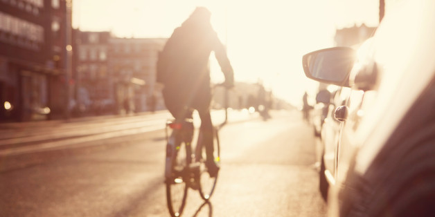 City commuters. High key blurred image of people riding a bike in the street. Unrecognizable faces.