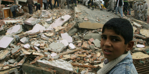 A BOY WATCHES RESCUE WORKERS TRYING TO LOCATE SURVIVORS UNDER RUBBLE OF DESTROYED BUILDING AFTER AFTERSHOCK IN MOROCCO. A boy watches rescue workers as they try to locate survivors under the rubble of a building that was destroyed by an early morning aftershock in the Moroccan village of Im-Zouren February 25, 2004. A strong earthquake shook northern Morocco early on Tuesday killing around 570 people around the Mediterranean port city of Al Hoceima, officials said. REUTERS/Anton Meres REUTERS