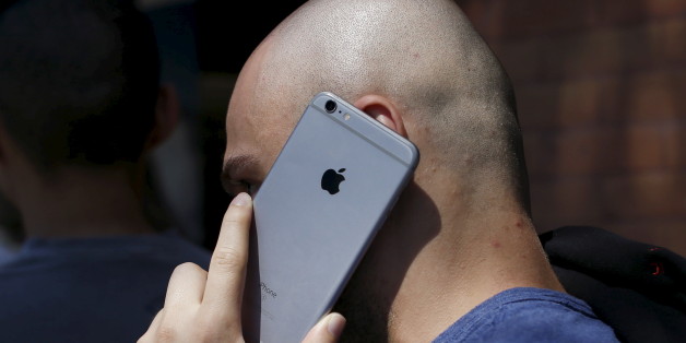 A person talks on his Apple iPhone while waiting in line near a Tesla Motors store to place deposits on the electric car company's mid-priced Model 3 which is expected to cost around $35,000 in Pasadena, California March 31, 2016. REUTERS/Mario Anzuoni