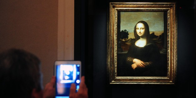 Members of the media take pictures during the media preview of The World Premiere of Leonardo Da Vinci's painting 'Earlier Mona Lisa' exhibition in Singapore on December 15, 2014. The World Premiere of Leonardo Da Vinci's exhibition will begin on December 16 till February 1, 2015. AFP PHOTO / MOHD FYROL RESTRICTED TO EDITORIAL USE, MANDATORY MENTION OF THE ARTIST UPON PUBLICATION, TO ILLUSTRATE THE EVENT AS SPECIFIED IN THE CAPTION. (Photo credit should read MOHD FYROL/AFP/Getty Images)
