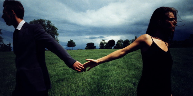 Couple in field, letting go of each other's hands