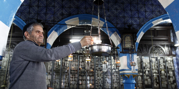 A Jewish man lights candles at the Ghriba synagogue in Djerba May 9, 2012. The Ghriba synagogue in Djerba, home to most of Tunisia's Jews, is built on the site of a Jewish temple that is believed to date back almost 1,900 years and attracts pilgrims each year. REUTERS/Anis Mili (TUNISIA - Tags: ANNIVERSARY POLITICS RELIGION TRAVEL)