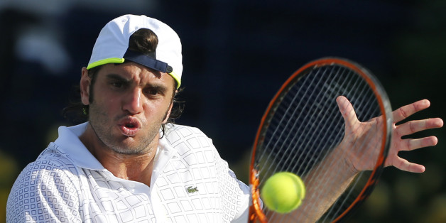 Malek Jaziri of Tunisia hits a return to Roger Federer of Switzerland during their men's singles match at the ATP Dubai Tennis Championships, February 25, 2013. REUTERS/Mohammed Salem (UNITED ARAB EMIRATES - Tags: SPORT TENNIS)