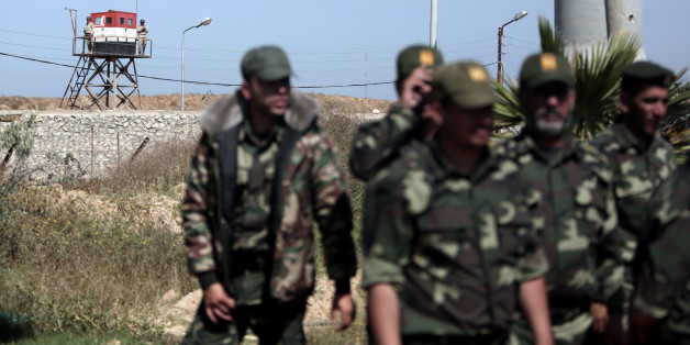Egyptian soldiers watch Palestinian Hamas security forces deployed on the Palestinian side of the border with Egypt in Rafah, southern Gaza Strip, Thursday, April 21, 2016. (Hamas has deployed forces along the Egyptian-Gaza border to counter Cairo's concerns it is aiding militants from the Islamic State group in Egypt's lawless Sinai Peninsula.AP Photo/ Khalil Hamra)