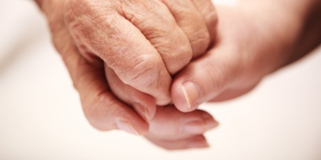 adult helping senior in hospital